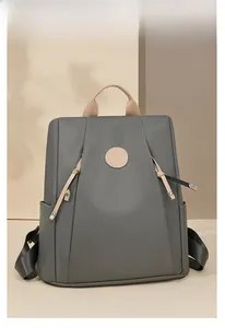 Close-up of lightweight nylon backpack showing side pocket and brown leather handle accents
