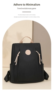 Detail of minimalist black nylon backpack featuring beige top handle and round logo patch