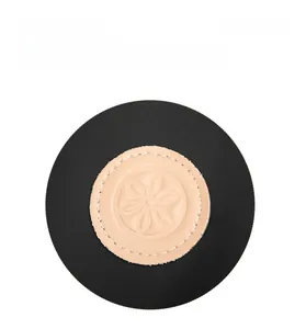 Macro view of embossed flower logo on beige leather patch with white stitching on nylon bag