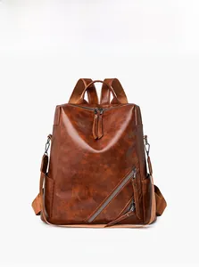 Macro shot of retro brown checkered backpack showing oil wax leather texture and side pockets