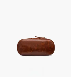 Detail view of the brown leather backpack bottom with textured pebble grain finish