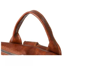 Close-up of vintage brown leather backpack with reinforced handle and metal zipper detail