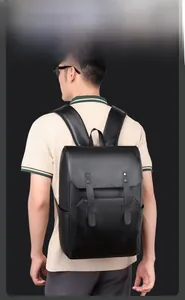 Rear view of a man wearing a black leather backpack with flap cover and metallic rivets