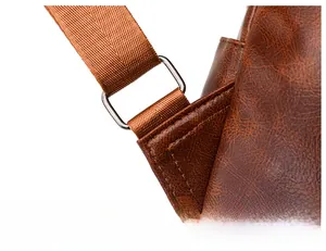 Detail of caramel leather backpack showing silver metal buckle and stitching on strap