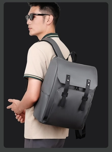 Detail view of a dark grey business backpack featuring matte finish and decorative buckles