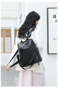 Fashionable black leather backpack with checkerboard texture shown on a female model