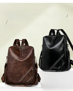 Close-up of checkerboard backpack showing brown and black PU leather texture with dual zippers