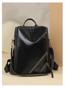 Close-up of black glossy checkerboard backpack with decorative zippers and side pockets