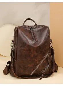 Detail of dark brown faux leather backpack with diagonal zipper and oily skin texture