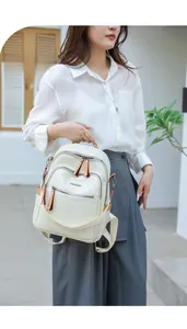Detail of cream PU leather backpack with rectangular embossing and orange zipper pulls