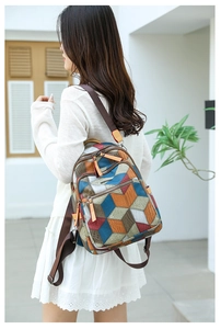 Close-up of stylish PU leather backpack with colorful geometric 3D patterns and metal zips