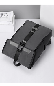 Détail du tissu imperméable gris et de la boucle noire sur le sac à dos robuste