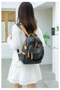 Detail of geometric quilted texture and contrast yellow zipper on black leather backpack