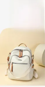 Close-up of white PU leather backpack featuring geometric embossing and brown accents