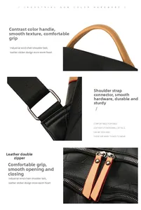 Detail of black pebbled leather backpack with contrast handles and sturdy metal zippers