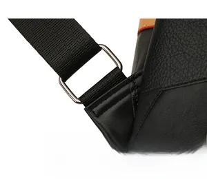 Close-up of metal strap buckle and nylon shoulder strap on black faux leather backpack