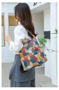 Detail of colorful geometric 3D pattern backpack with stylish leather tassel charm