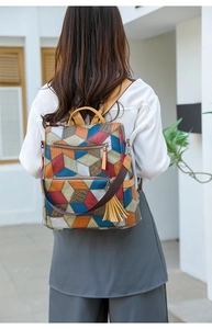 Detailed back view of a geometric colorful backpack with embossed texture and tassel charm