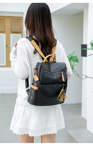 Detail of black PU leather backpack with geometric stitching and tassel decor