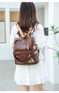 Detail of dark brown PU leather backpack with vintage fringe and stylish patchwork texture