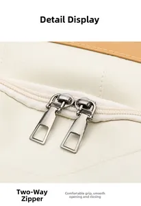 Detail view of smooth two-way metal zipper on premium cream faux leather backpack