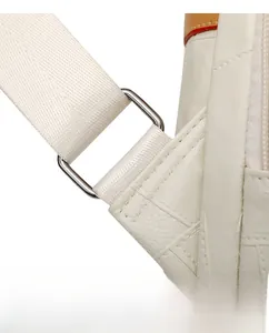 Macro detail of silver hardware buckle and lychee grain leather on off-white backpack