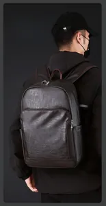 Vue détaillée d'un sac à dos en cuir marron avec poches latérales et zips argentés