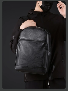 Détail du sac à dos professionnel en cuir PU noir avec poche frontale zippée et texture lisse