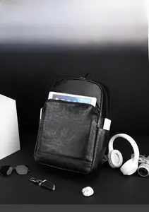 Détail des poches du sac à dos en cuir montrant le rangement tablette et batterie