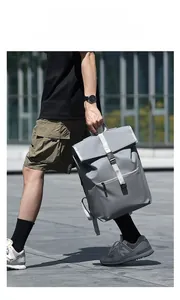 Détail d'un sac à dos gris imperméable avec boucle métallique et design tactique à rabat