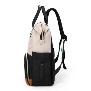 Vue latérale du sac à dos bicolore en toile avec fond en cuir brun et fermetures dorées