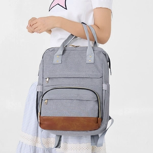 Détail du sac à dos gris avec base renforcée en similicuir marron durable et chic