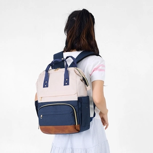 Vue arrière du mannequin portant le grand sac à dos imperméable en couleurs contrastées
