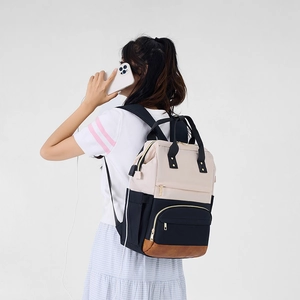 Vue latérale du sac à dos pour ordinateur beige et noir avec port USB porté par un modèle