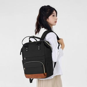 Détail d'un sac à dos noir pour femme avec base renforcée en cuir marron