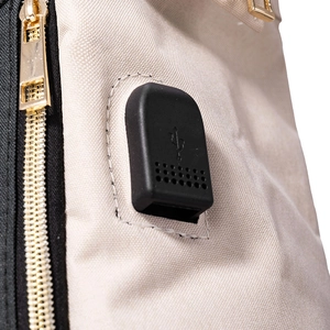 Détail du port de charge USB intégré et du zip doré sur ce sac à dos d'affaires pour femme