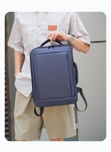 Detail of navy blue business backpack showing side handle for dual carrying options