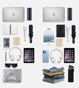 Flat lay di accessori da viaggio tra cui laptop e cuffie per zaino capiente da lavoro