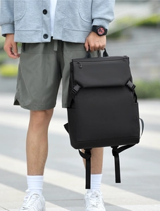 Detail of minimalist black laptop backpack featuring durable fabric and side buckle closure