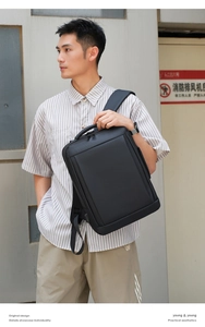 Modern black business backpack featuring waterproof fabric on a male model's shoulder