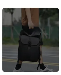 Detail of a black large-capacity travel backpack with flap closure and buckle straps