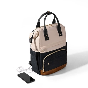 Détail d'un sac à dos multifonction avec port USB et design contrasté crème et noir