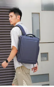 Navy business commute backpack with USB charging port shown on male model outdoors