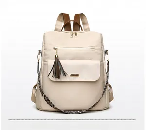 Detail of off-white backpack with brown leather handle and leopard print shoulder strap