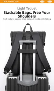 Detail of the luggage strap on a black travel backpack secured to a suitcase handle