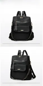Detail of black nylon backpack with gold hardware, leopard strap and tassel charm