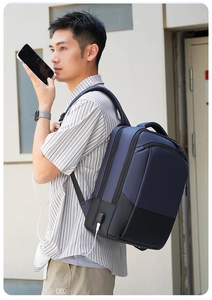 Detail view of navy blue business backpack showing the side USB charging port and multi-layer zippers