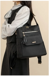 Detail of black backpack with leopard print strap and gold hardware on female model