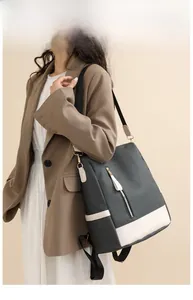Detail of grey quilted backpack with cream leather trim and bicolor woven strap