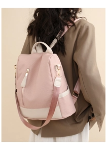 Pink woven backpack for women with creamy leather accents and gold zippers on the back
